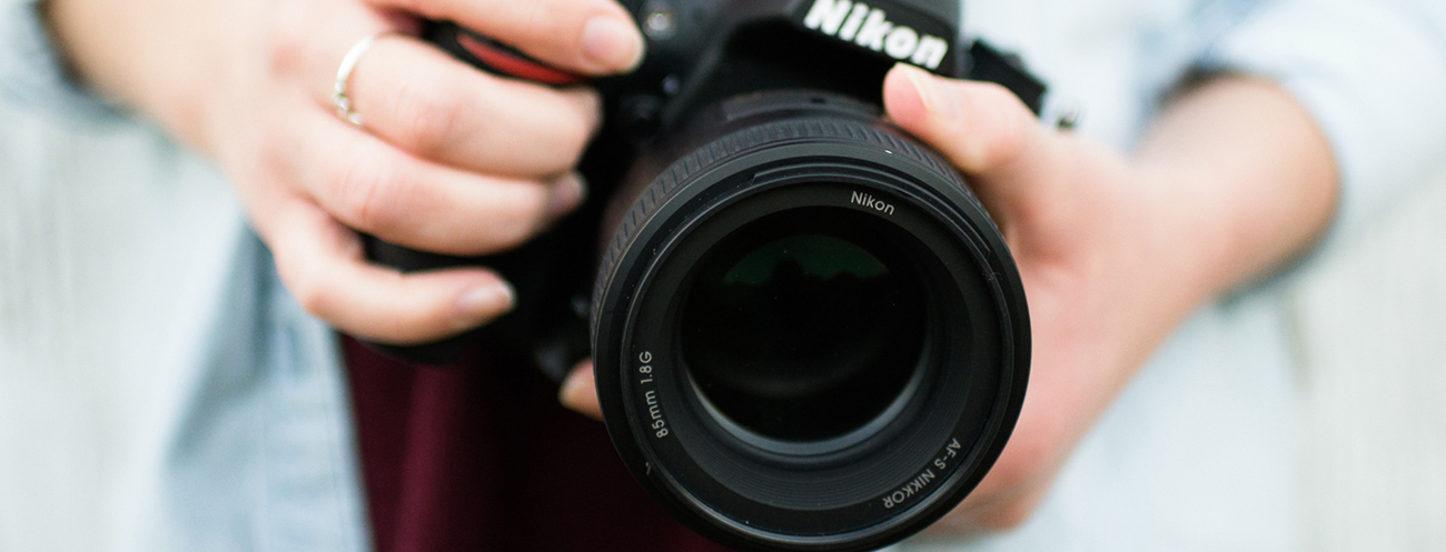 Close up of a camera lens in someone's hands